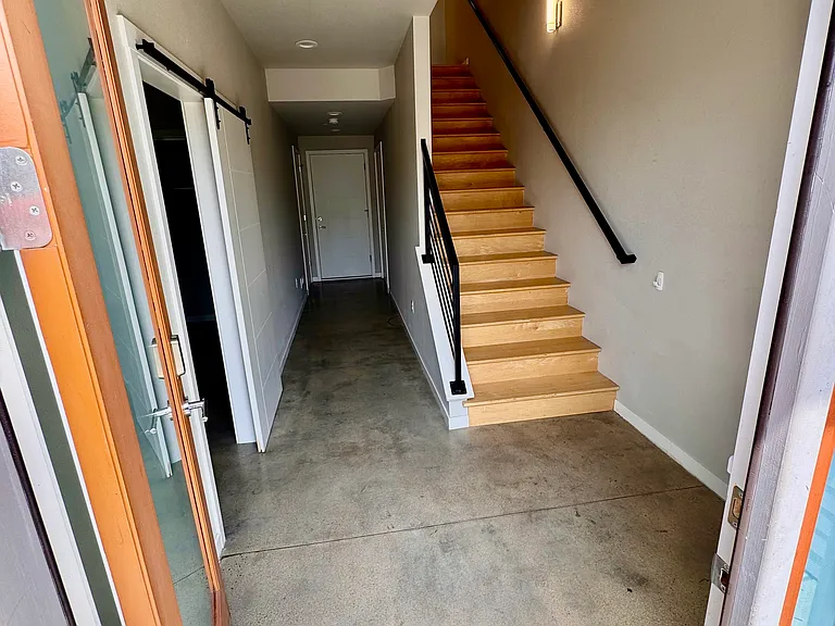 Front door entrance looking towards the door to the garage and stairs to second floor living area. Storage under the stairs.