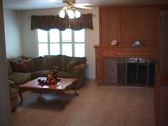 Living room, new tile floors and baseboards, plantation shutters, granite frpl