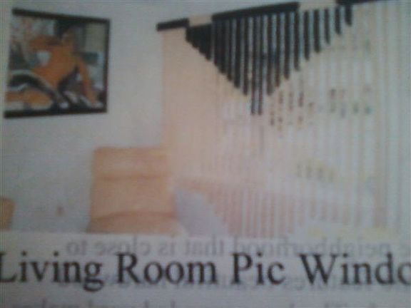 Living room area with large picture window, custom blinds & custom mirrors