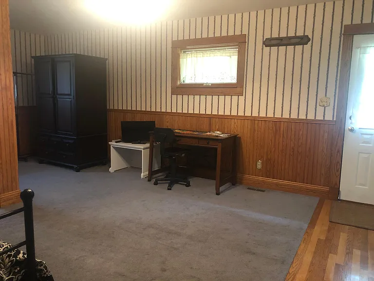 Living area, facing south, with entrance door.