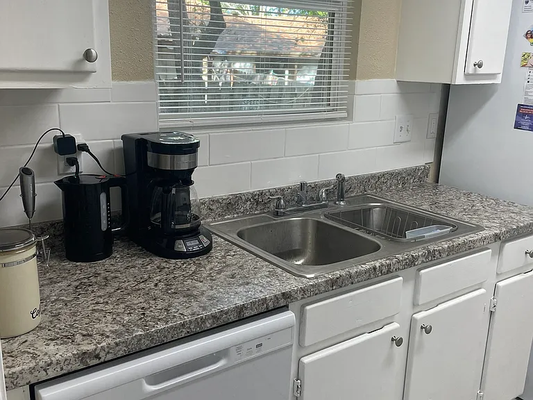 View of the yard and stainless double sinks with ample counter space.
