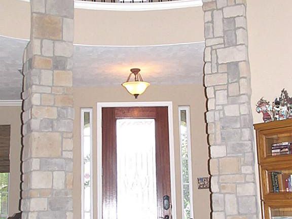 IMPRESSIVE TWO-STORY ROTUNDA ENTRY WAY WITH STONE COLUMNS & IRON RAILING