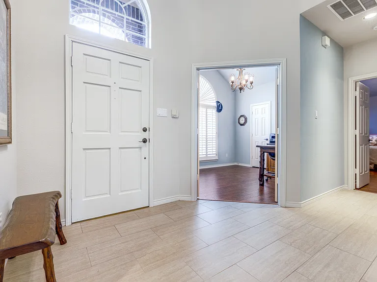 View of the front entry area, with two bedrooms to the left side of the front door, the one facing front is used as an office. Wood and tile floors.