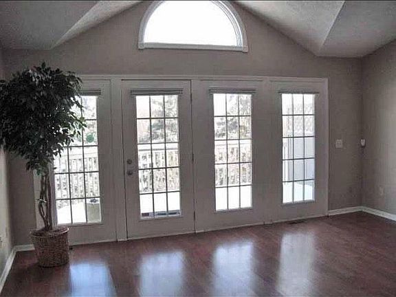 Vaulted ceiling in light filled Living Room with French doors leading to 2nd story deck