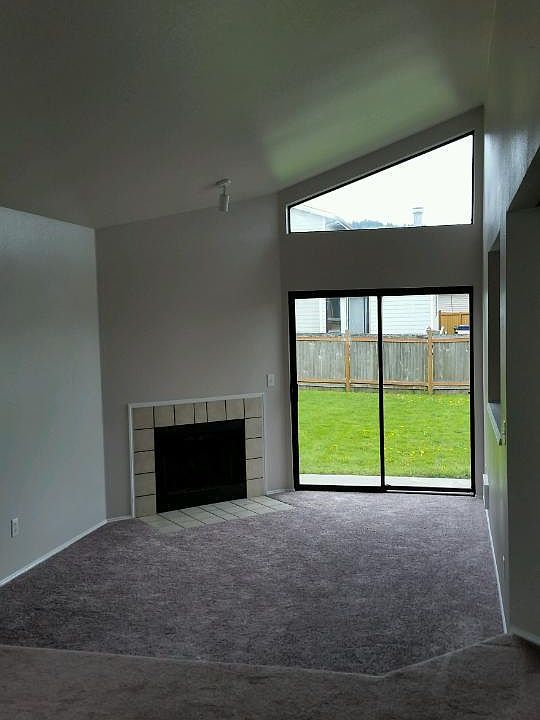 Living Room with cozy wood-burning fireplace, sliding patio door to spacious outside back yard. Office/Den off to right.