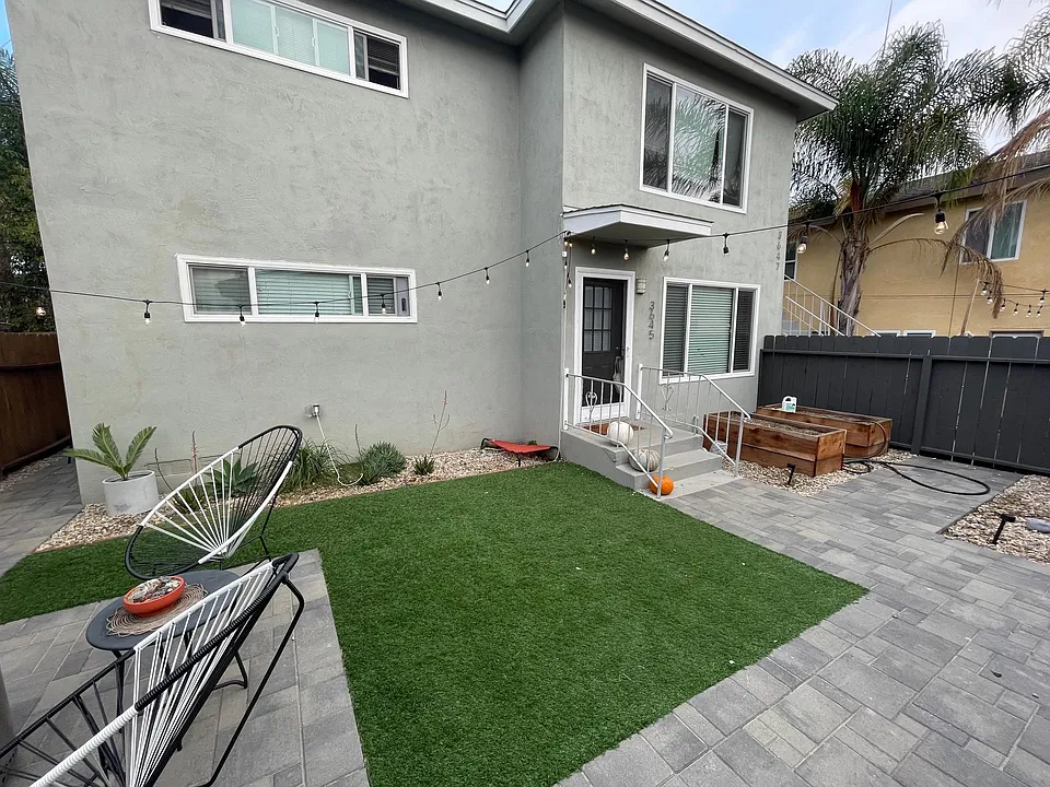 New photo of front-yard. Fully-enclosed, low-maintenance, front yard with new artificial turf, pavers and redwood planter boxes.