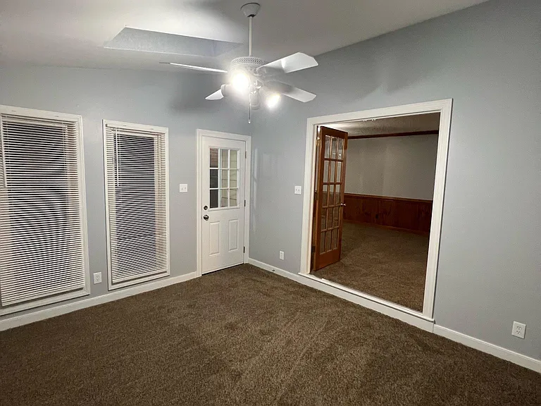 Photo of the florida room with skylights. New door to the back deck/backyard pictured left and double door entry looking into family room