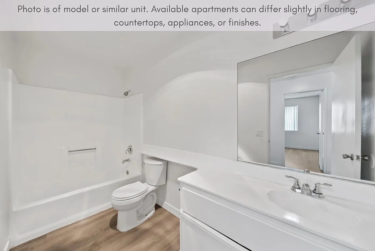 Bright bathroom with a full tub and generous counter space for everyday use. - Suncrest Apartments