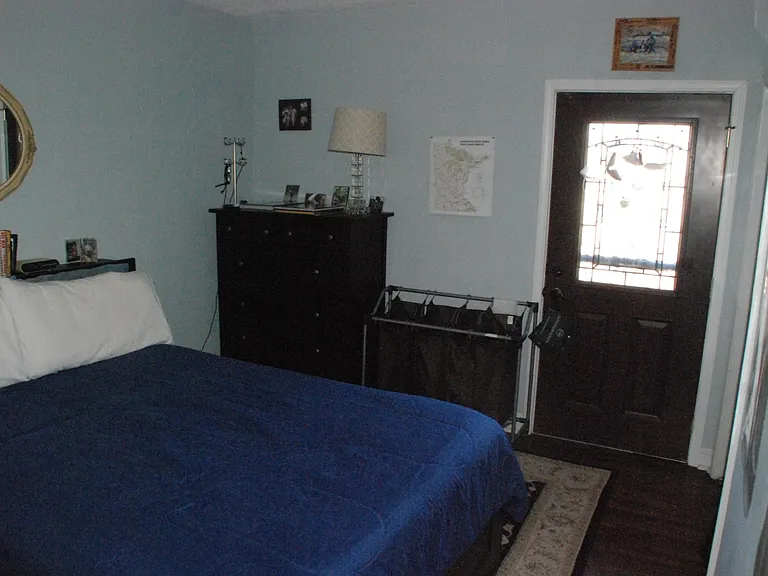 Larger bedroom (12.25' x 14.25') holds queen bed, high dresser and long low dresser.