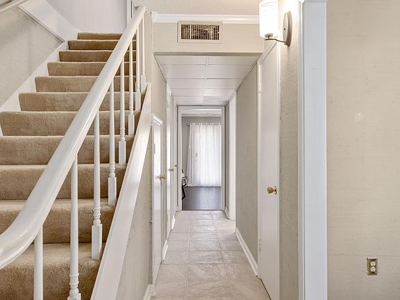 hallway to living room and French doors that open to patio and back gated area and back covered parking