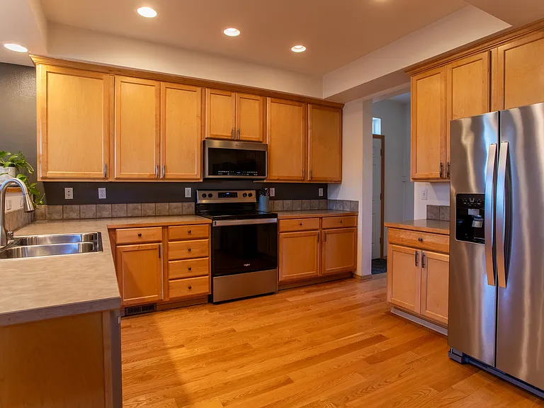 Spacious kitchen with stainless steel appliances and new cabinet hardware.
