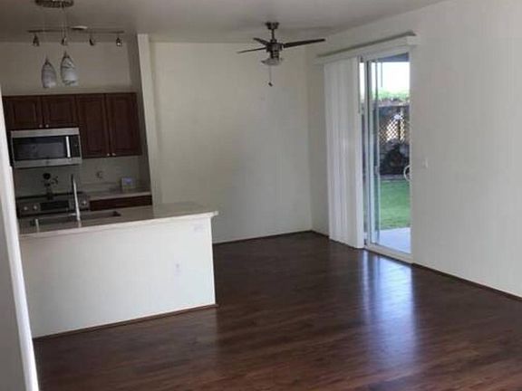 View of living room from front door, dining area has glass sliding door to access back patio and large backyard.