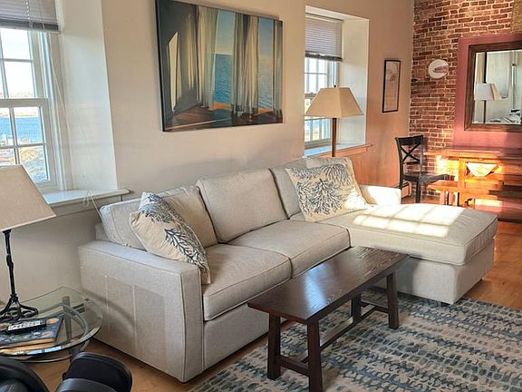 New Room and Board sectional complete this living/dining area with beamed ceilings. Windows overlook the harbor.