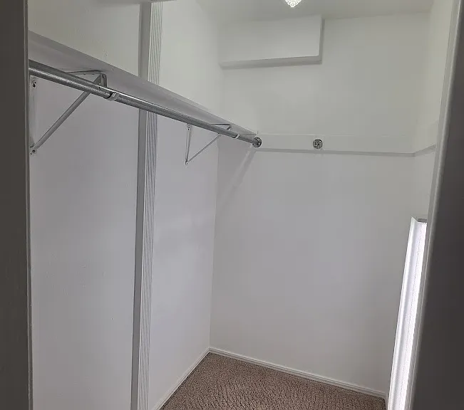 Large walk-in closet with floor to ceiling lighting.
