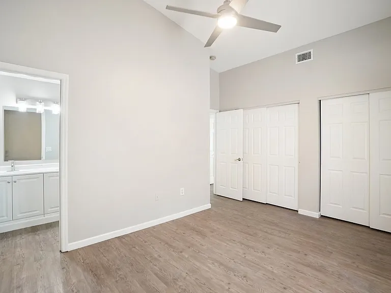 Spacious master suite with large windows, plenty of natural light & functional luxury with 'his and hers' closets