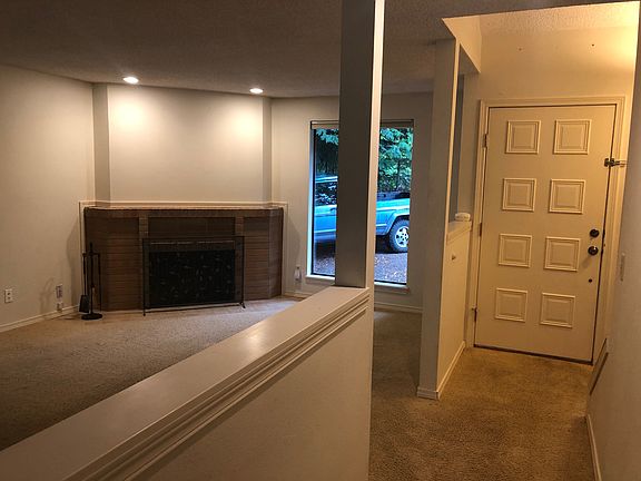 Entry way and partial living room with wood burning fireplace.