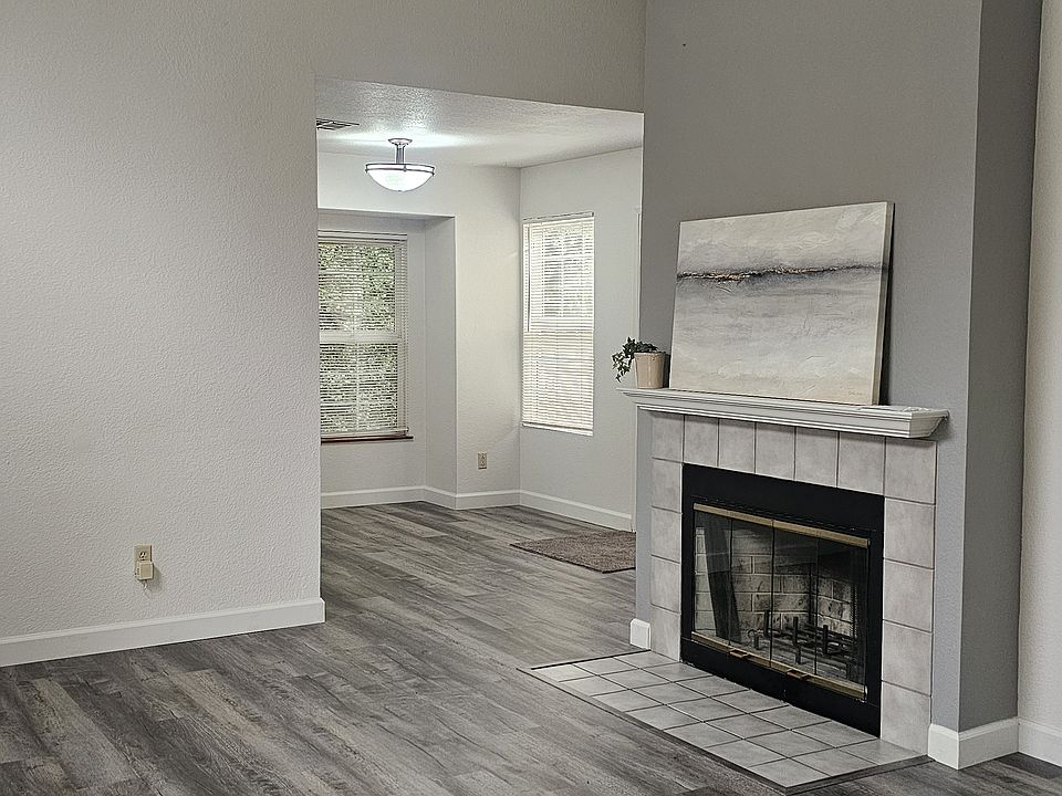Welcoming living room with new LVP floors , fireplace, plenty of natural light and fireplace. Open space to dining room and deck