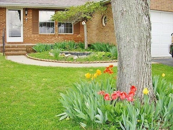 Flowers & a water feature enhance the front of the home.