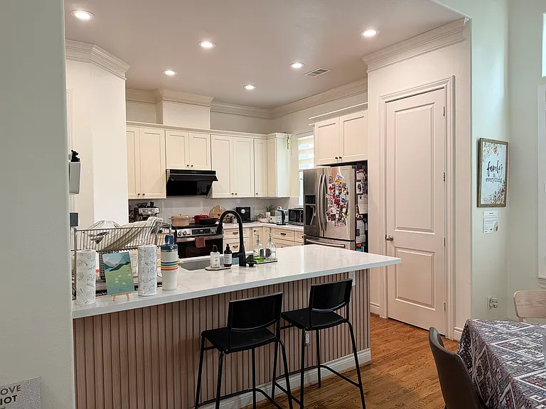 Renovated kitchen with new island design and white cabinets, and extra storage spaces.