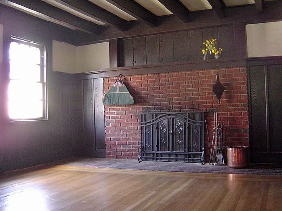 living room with wood-burning fireplace and oak panels