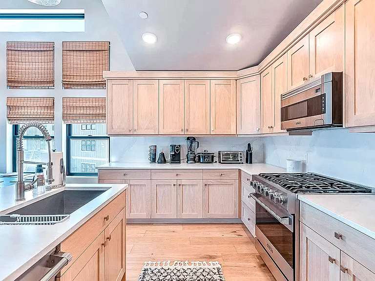 Kitchen cooktop area with six-burner gas range, subway tile backsplash, and bright window bringing in natural light