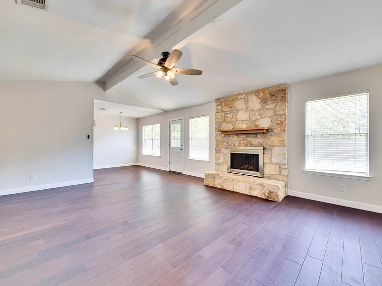 Spacious Living Room: Relax and unwind in the expansive living room complete with vaulted ceilings and a cozy fireplace, creating a warm and inviting atmosphere.