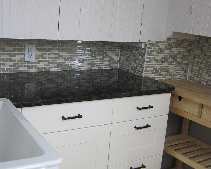 pantry with view of granite countertops, tile backsplash and