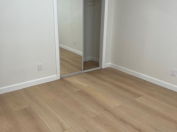 Bedroom #1 with mirrored closet doors and new blinds.