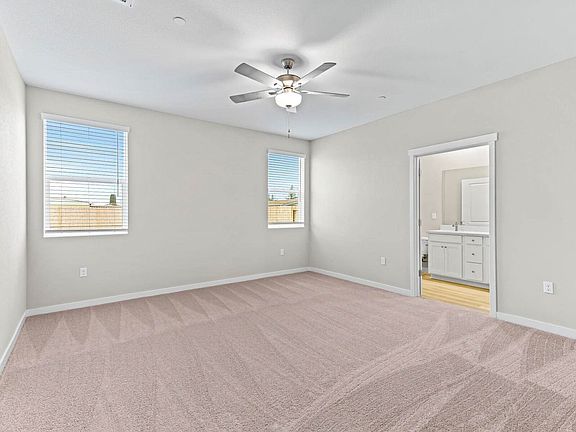 The master bedroom has large windows and a ceiling fan.