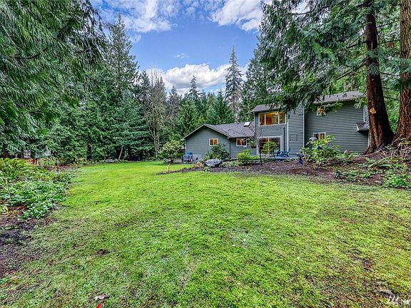 The .410 acre lot is surrounded by trees with an open, light-filled backyard.
