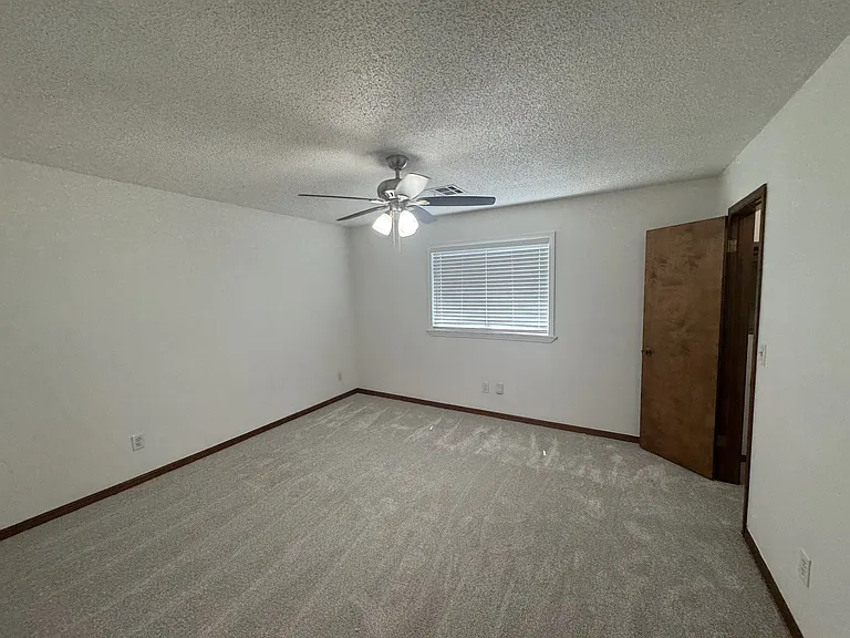 Secondary bedroom with ceiling fan and Large walk-in closet.