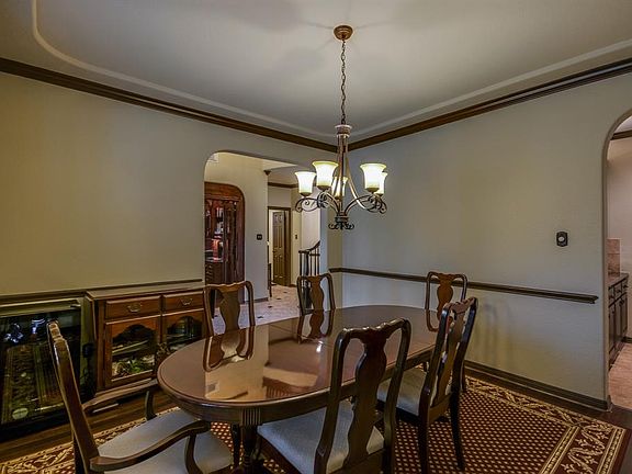 Formal dining room features updated lighting, crown molding and hardwood flooring, arched doorway leads to butlers pantry.