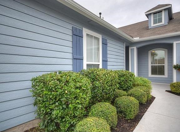 Manicured planting beds add immediate appeal at this choice Sun City Texas Monterey Cottage, where y