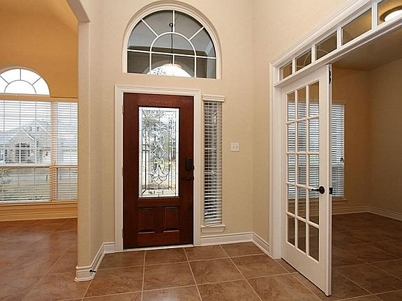 Entry/Foyer shows attractive tile flooring with rich wood door and French Doors to study...