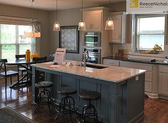 Gourmet Kitchen with White cabinets and grey island. Granite tops with white subway tile.