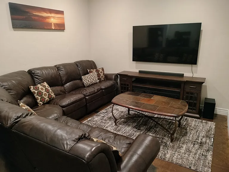 The family room features a Smart TV with a soundbar for streaming your favorite shows and an electric fireplace for added warmth and ambiance, creating a cozy entertainment space.