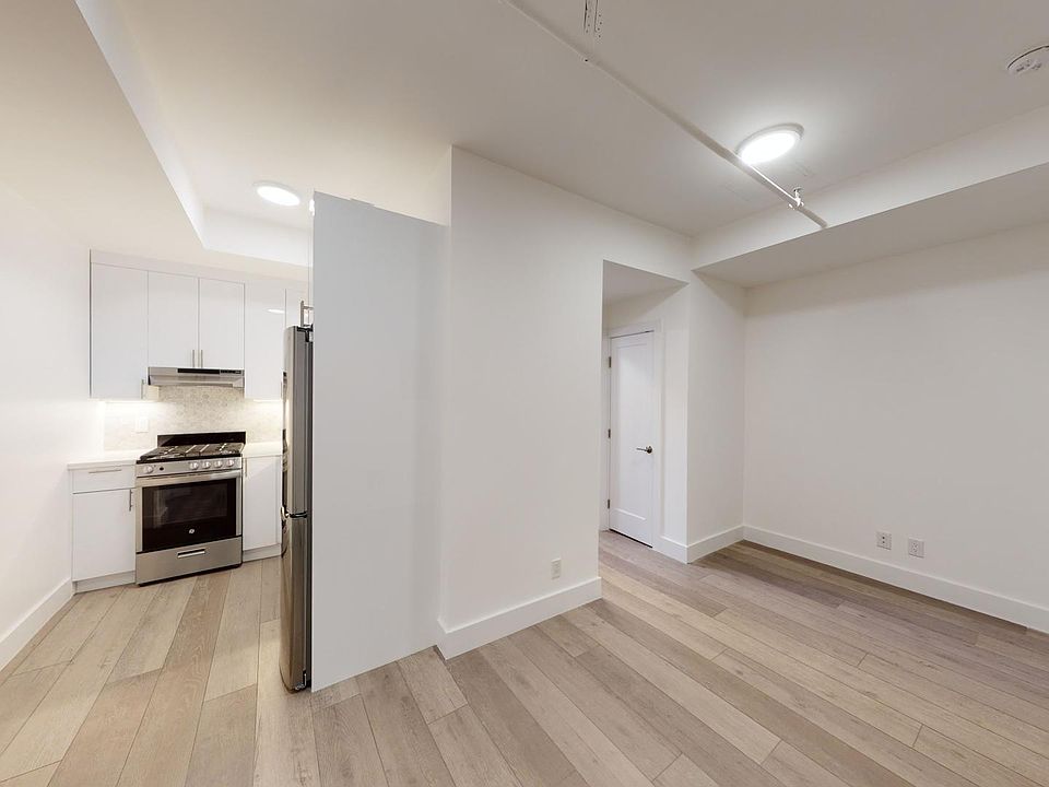Living area with a wood-like flooring and an entrance to the kitchen