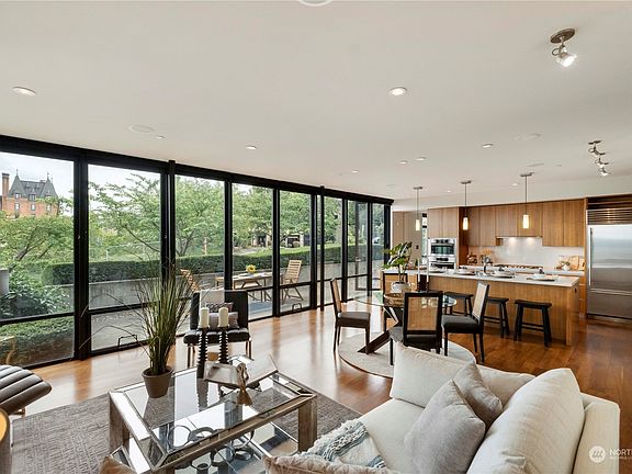 Living Room: Experience tranquility and comfort in this spacious living room, boasting floor-to-ceiling windows that frame breathtaking views of the city, Stadium High School, Port of Tacoma and Commencement Bay. Picture yourself relaxing here with loved ones, soaking in the stunning scenery and natural light.>