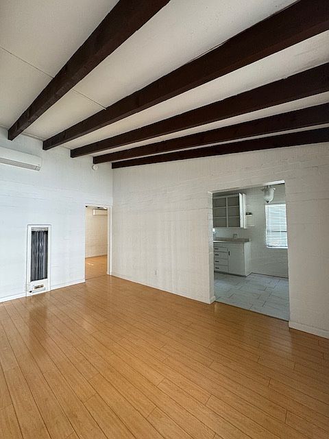 BEAMED, VAULTED CEILING IN LIVING ROOM (LOOKING INTO BEDROOM IN BACK AND KITCHEN/DINING ON RIGHT)