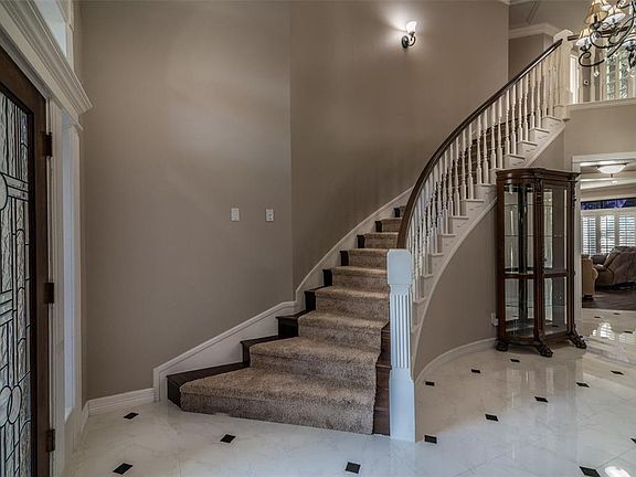 Graceful curved staircase. The entry light fixture is on a power lift that can be lowered for maintenance.