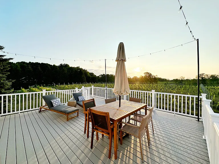 The expansive back deck has a seasonal furniture setup
