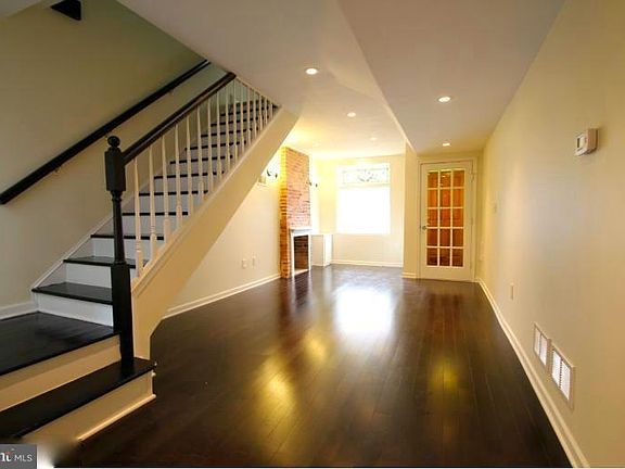 1st Floor: View of Living room looking toward front of house with stairs to second floor.
