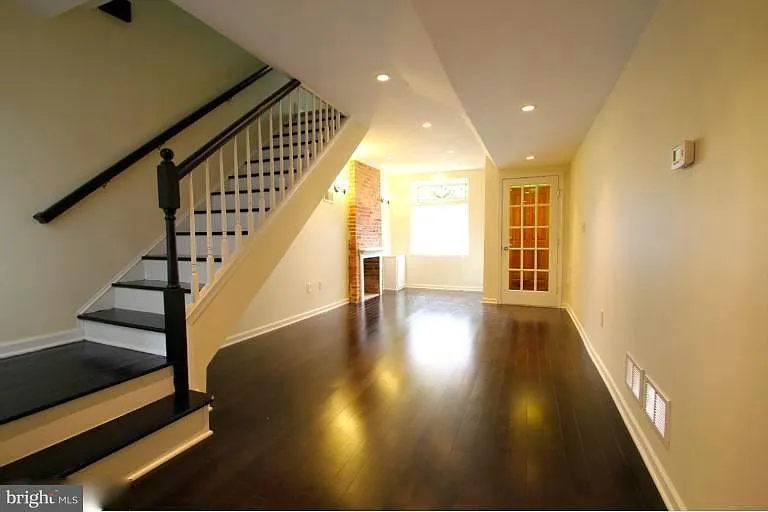 1st Floor: View of Living room looking toward front of house with stairs to second floor.