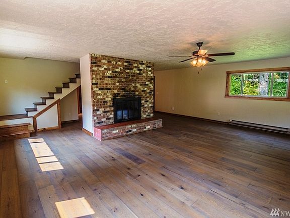 Spacious, bright and light living room area with wood fireplace to keep you warm and cozy all winter. New laminate "wood look" f