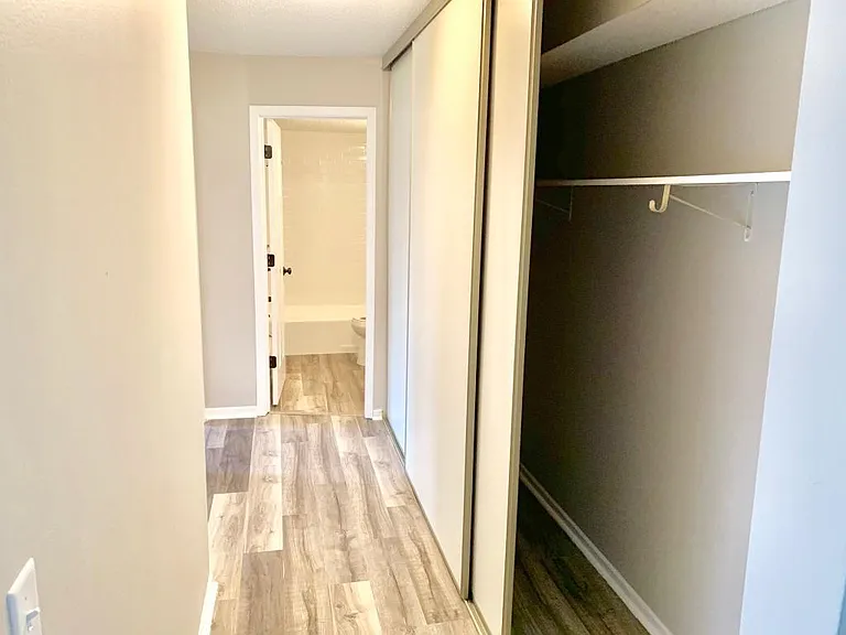 Hallway to bedrooms and bathroom, with large closets for storage.