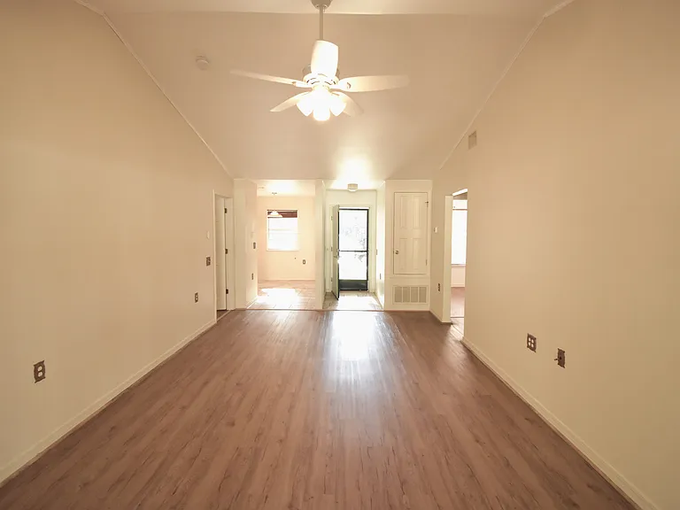 Living room looking at kitchen entrance and front door.