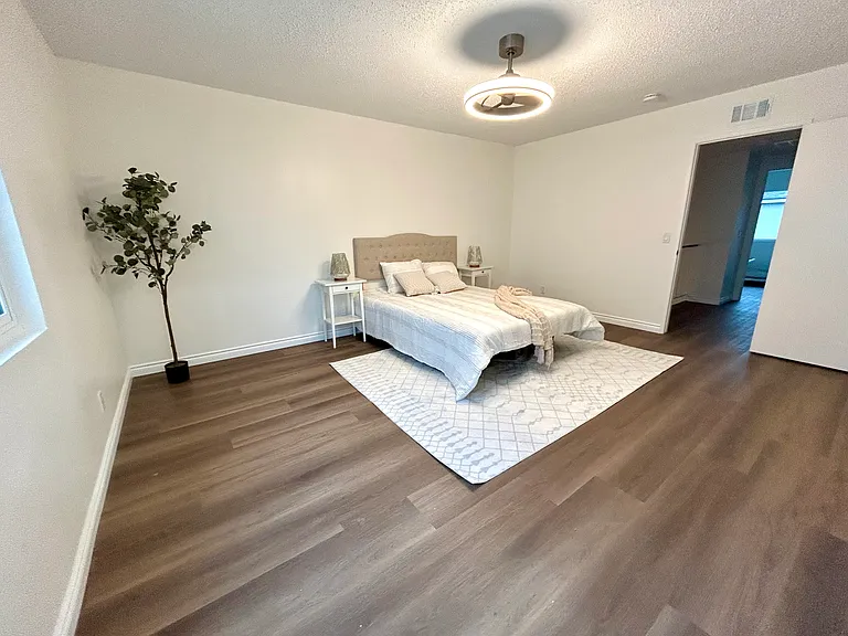 Primary master bedroom on second floor with walk-in closet and private bathroom, new flooring, new windows, modern ceiling fan