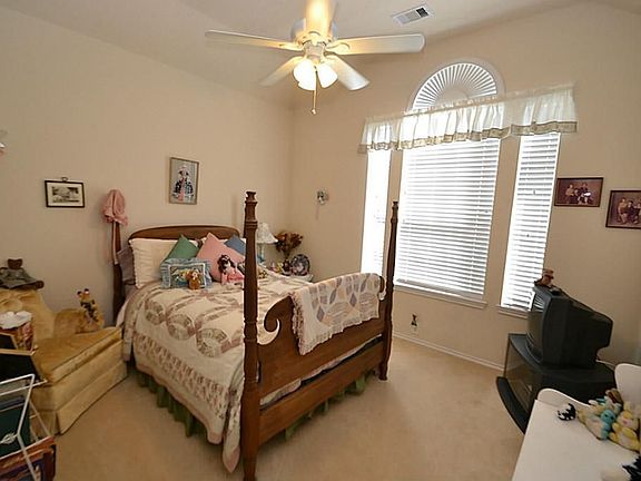 Bedroom accented by raised ceilings, ceiling fan with light fixture, two inch window blinds and nice closet space,