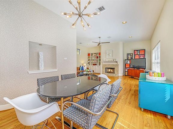 Beautiful open concept dining and living rooms features wood floors, high ceilings, beautiful wall coverings, highlighting one of many curved architectural details in the home.