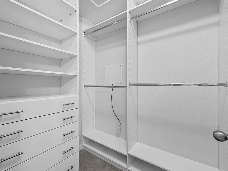 primary closet with custom closet system for efficiency